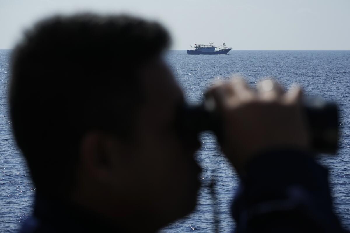 A suspected Chinese militia ship passes the Philippine Coast Guard BRP Malabrigo.