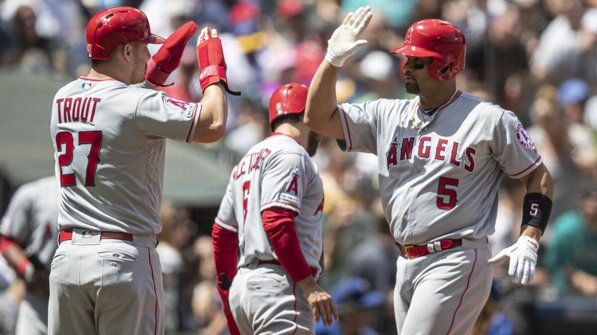 Angels slugger Albert Pujols, right, is congratulated by Mike Trout after hitting a three-run home run against the Seattle Mariners.