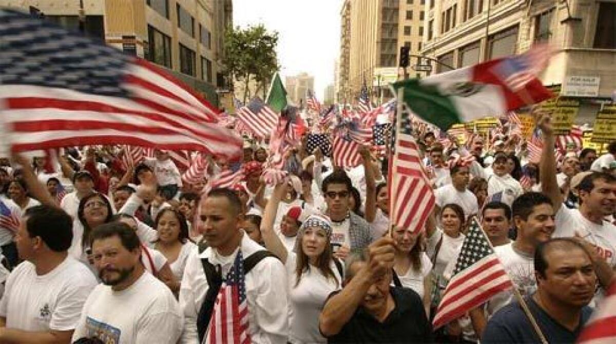 RAISING THEIR BANNERS: Immigrants and supporters gather at Olympic Boulevard and Broadway in one of two Los Angeles marches that attracted hundreds of thousands of demonstrators.