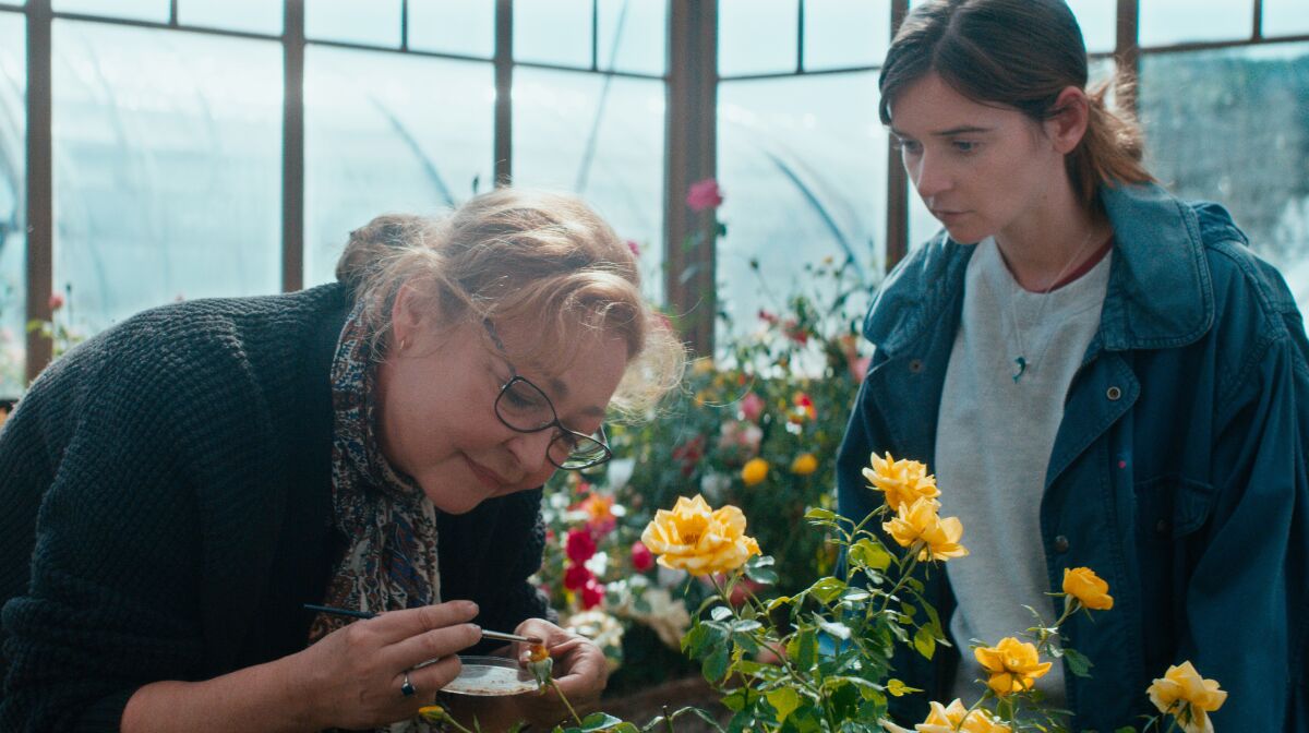 Two women in a greenhouse tending flowers in the movie “The Rose Maker.”