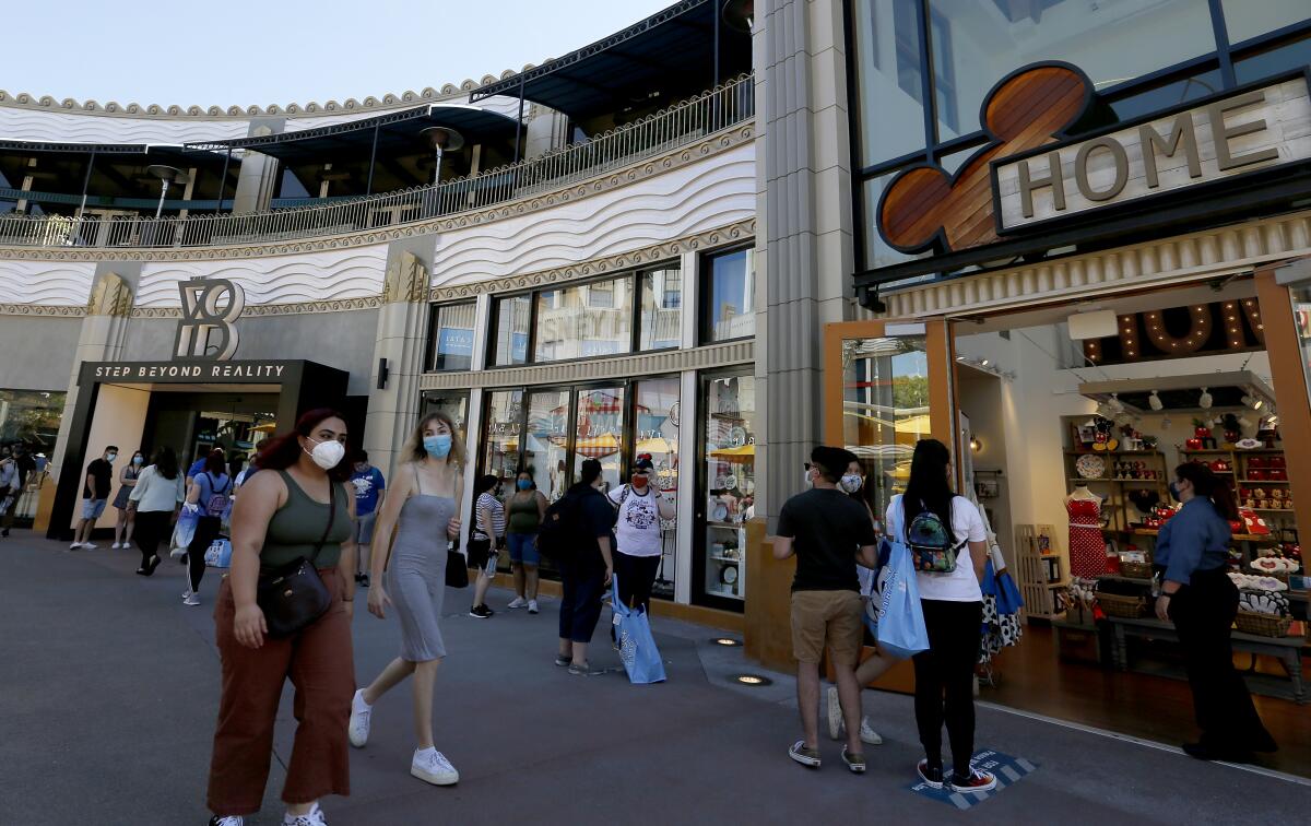 People stroll through the Downtown Disney shopping district in Anaheim in July.