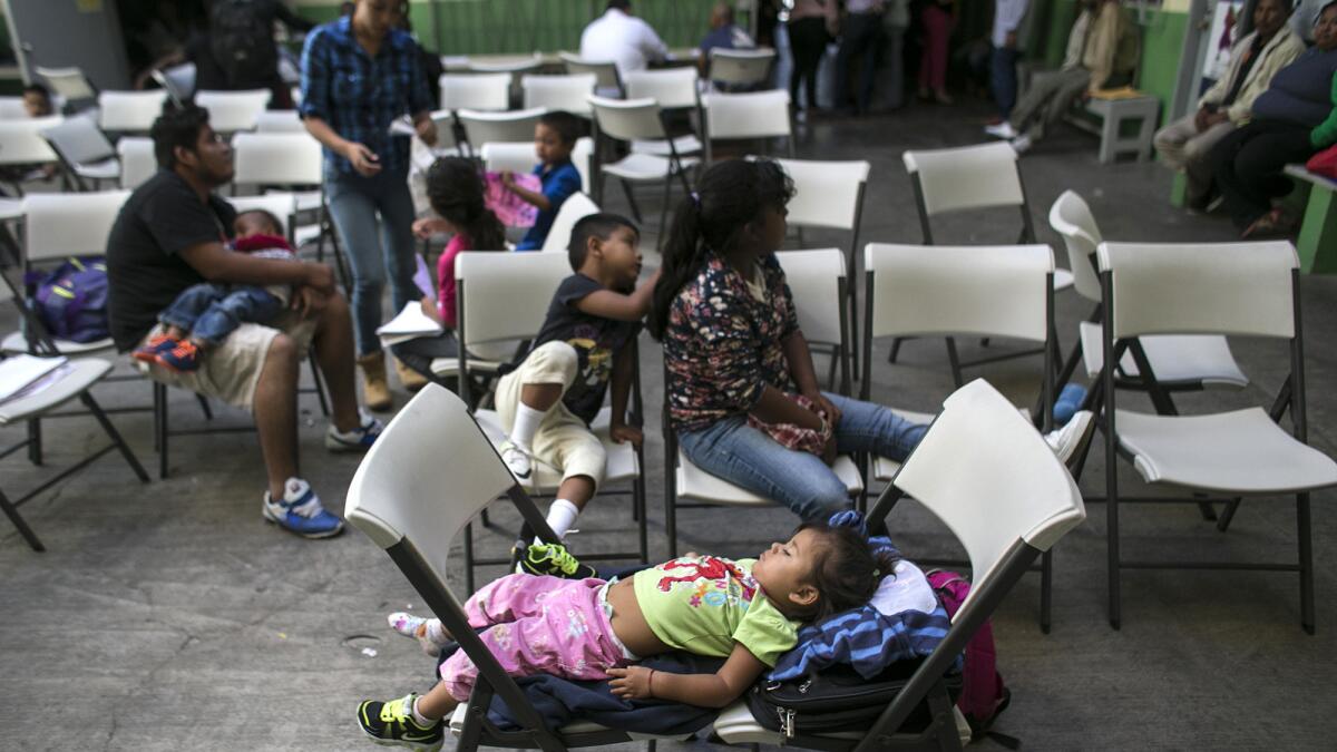 Children wait while their parents consult with attorneys and advocates at an immigration clinic in Tijuana.