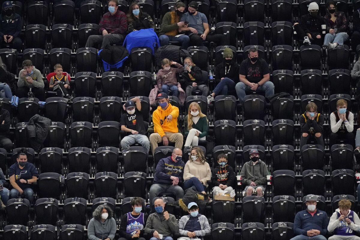 Small groups of Utah Jazz fans surrounded by empty seats watch a game against the Phoenix Suns on Thursday in Salt Lake City.
