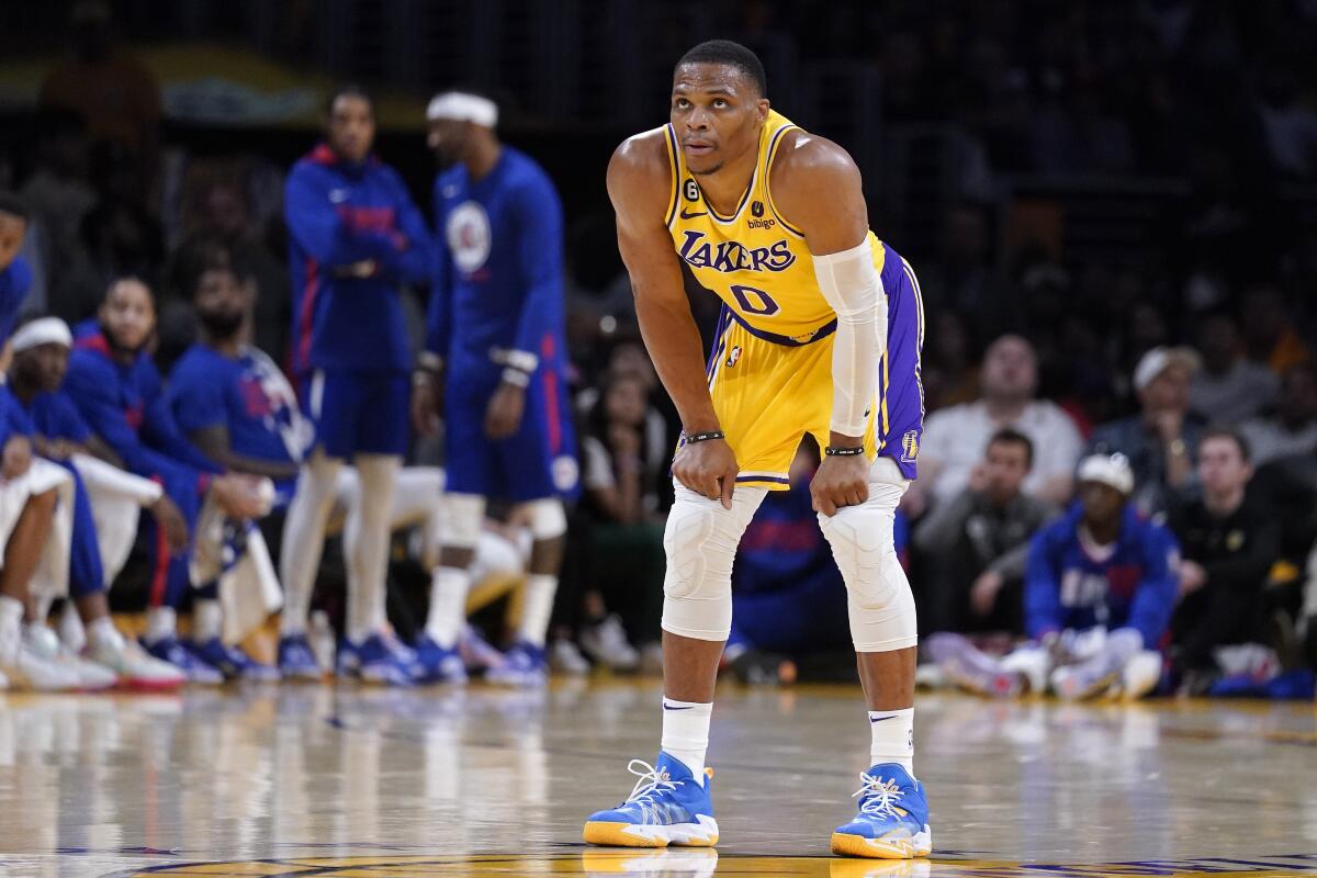 Lakers guard Russell Westbrook stands on the court bent forward with his hand on his knees.