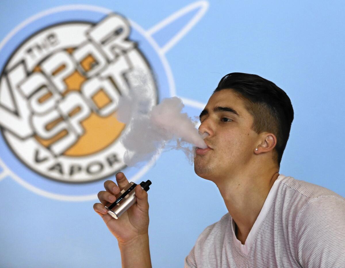 Will Braaten exhales vapor from an e-cigarette at the Vapor Spot in Sacramento. Thousands of “vape” shops have sprung up nationwide in recent years.