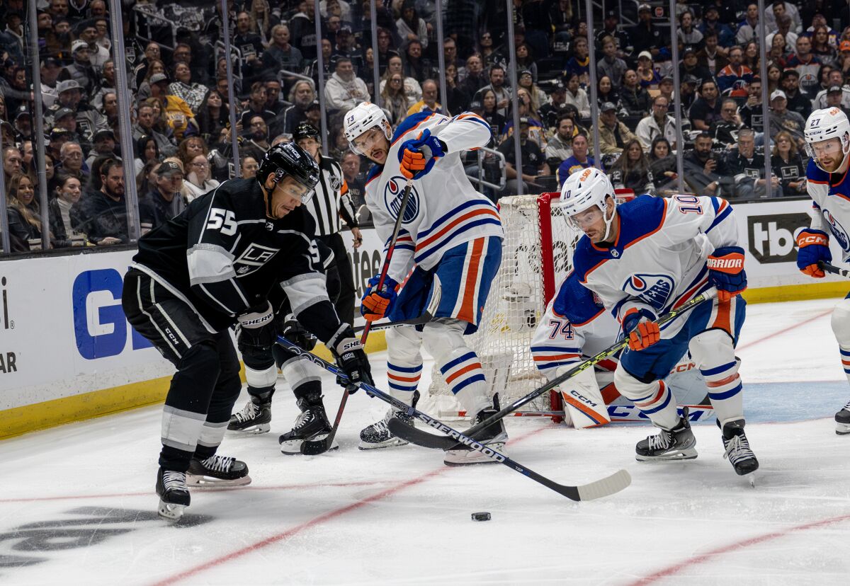 Kings forward Quinton Byfield, left, and Edmonton Oilers forward Derek Ryan battle for the puck.