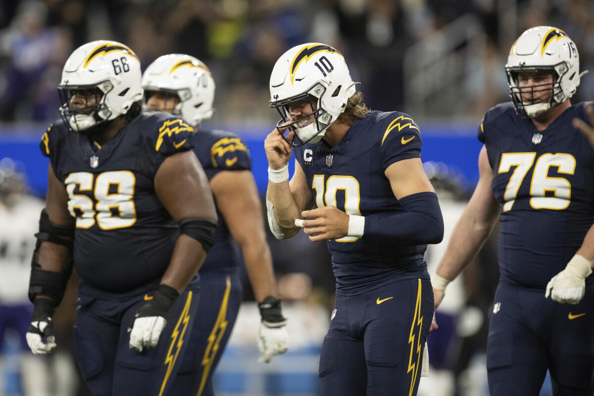 Chargers quarterback Justin Herbert (10) and the offensive line jog back to the bench.