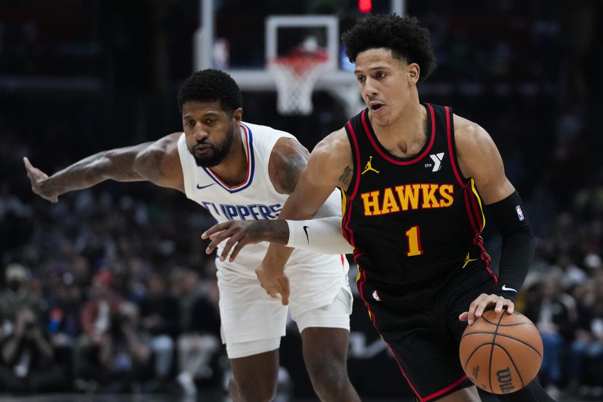 Atlanta Hawks forward Jalen Johnson controls the ball in front of Clippers forward Paul George.