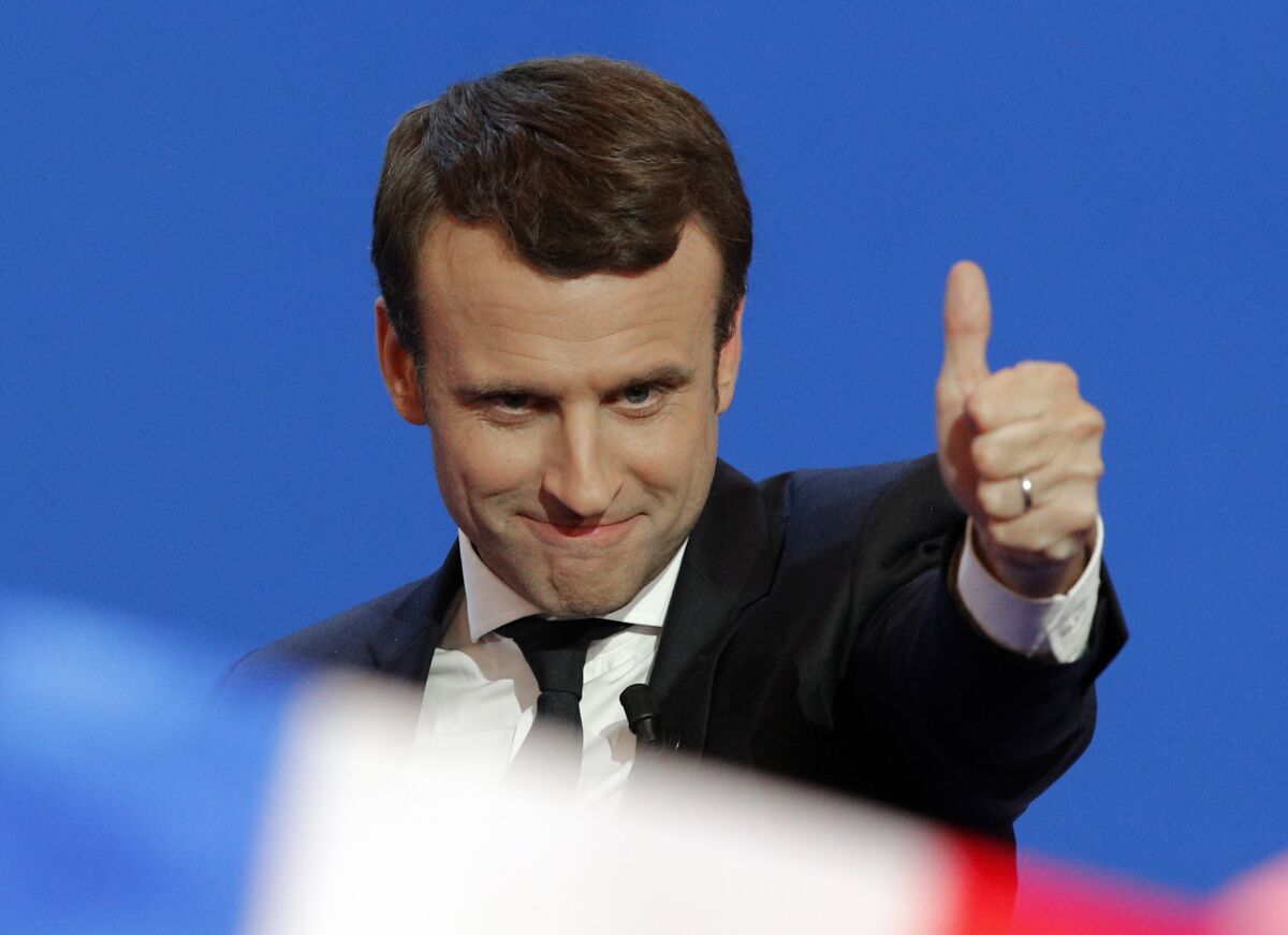 FILE - French centrist presidential candidate Emmanuel Macron thumbs up as he addresses his supporters at his election day headquarters in Paris, April 23, 2017. French President Emmanuel Macron hasn't officially declared that he's a candidate for April's presidential election yet. Critics say he's unfairly using his taxpayer-funded presidential pulpit to campaign for a second term while dragging out his widely expected announcement as long as possible. (AP Photo/Christophe Ena, File)