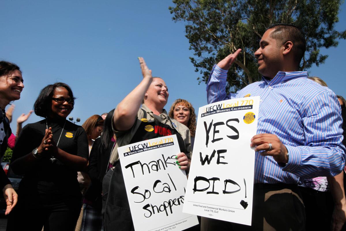 United Food and Commercial Workers Union on Monday released a report showing steep declines in wages since 1999. Here, Vons checker Angela Baker and Ron Solano, high-five following the decision to not go on strike Sept.20, 2011.
