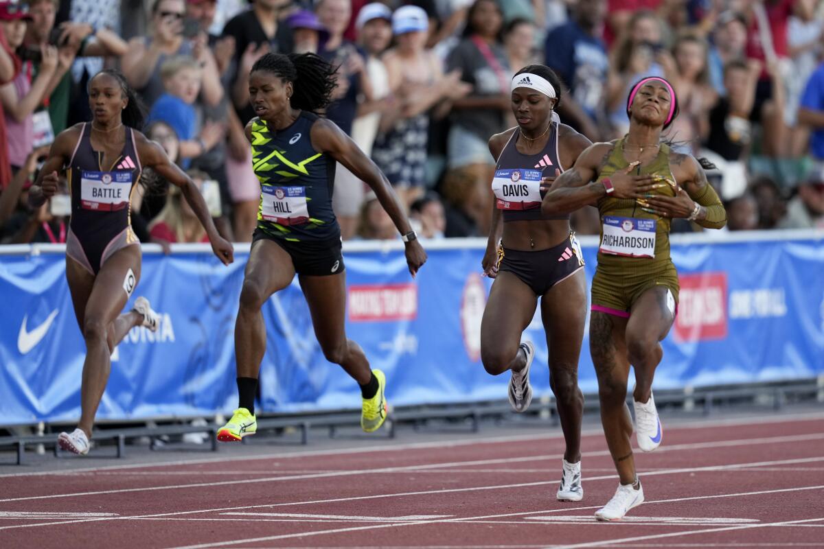 Sha'Carri Richardson, right, celebrates as she crosses the finish line to win the women's 100-meter final.