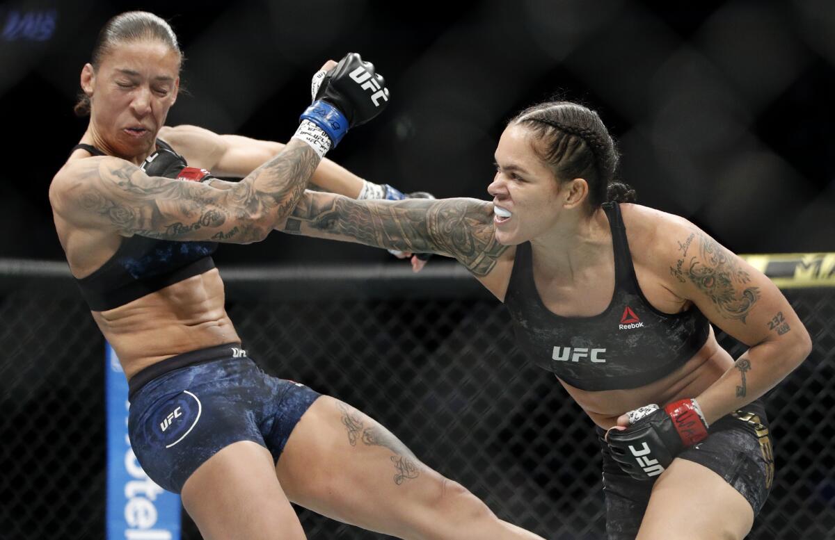 Amanda Nunes, right, hits Germaine de Randamie 