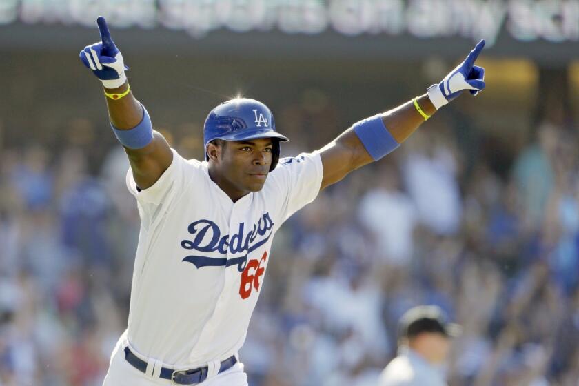 Dodgers right fielder Yasiel Puig celebrates after hitting a walk-off home run in the 11th inning of the Dodgers' 1-0 victory over the Cincinnati Reds on Sunday.