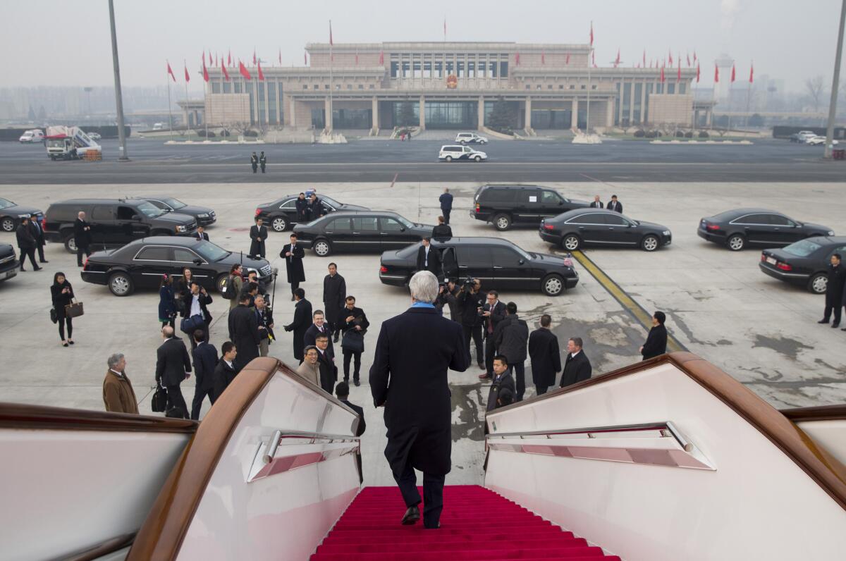 U.S. Secretary of State John F. Kerry walks off his plane after arriving at Beijing International Airport on Friday.