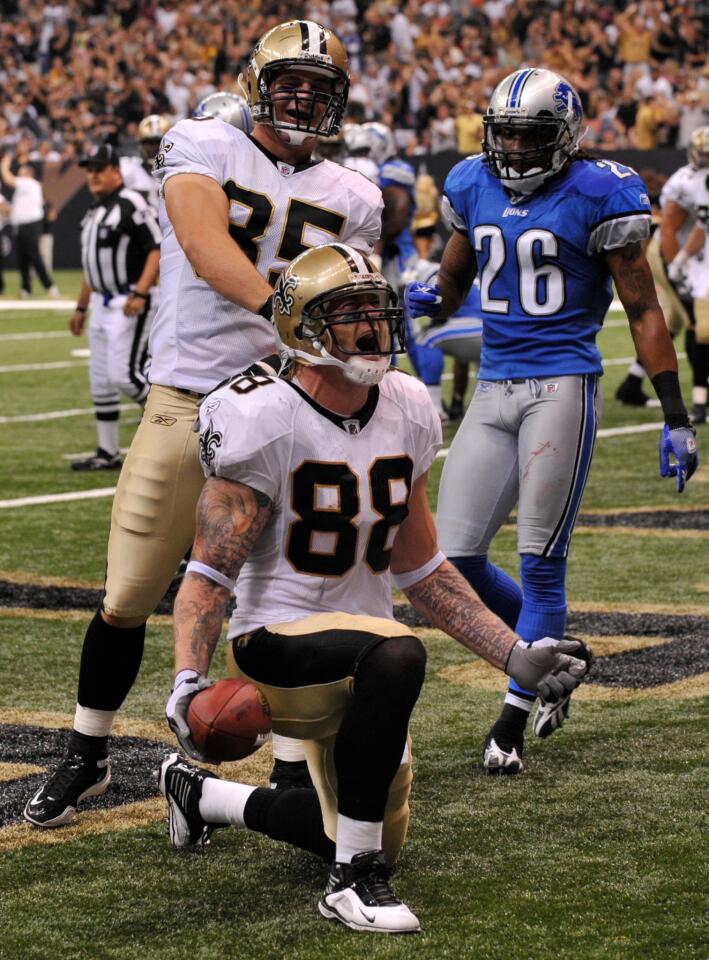 As Detroit Lions safety Louis Delmas (26) walks back to the bench, New Orleans Saints tight end Dan Campbell (89) celebrates with tight end Jeremy Shockey (88) who just pulled in a touchdown pass in the first half of an NFL game between the Detroit Lions and New Orleans Saints in the Louisiana Superdome in New Orleans, Sunday, Sept. 13, 2009. (AP Photo/Bill Feig)
