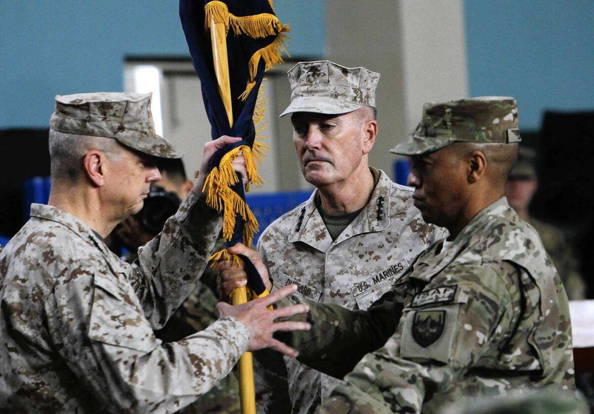 Gen. John R. Allen, left, hands a flag to Gen. Joseph F. Dunford Jr. during a ceremony in Kabul, at which Dunford took over command of the U.S.-led NATO force in Afghanistan.