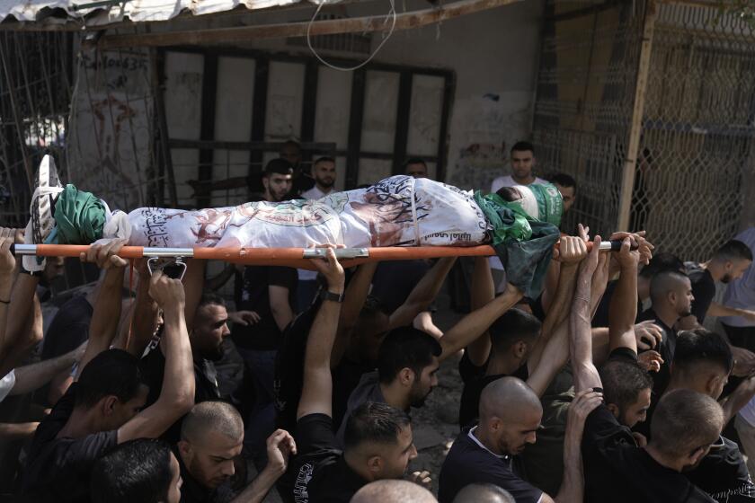 Mourners carry the body of militant Haitham Balidi, draped in the Qassam Brigade flag of the Hamas militant group's military wing, in Tulkarem refugee camp in the West Bank, Saturday, Aug. 3, 2024. He was killed in an Israeli drone strike, which Israeli military said struck five suspected terrorists in a vehicle on their way to carry out an attack. (AP Photo/Majdi Mohammed)