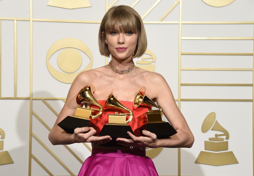 FILE - Taylor Swift poses in the press room with the awards for album of the year and pop vocal album for "1989" and best music video for "Bad Blood" at the 58th annual Grammy Awards in Los Angeles on Feb. 15, 2016. (Photo by Chris Pizzello/Invision/AP, File)