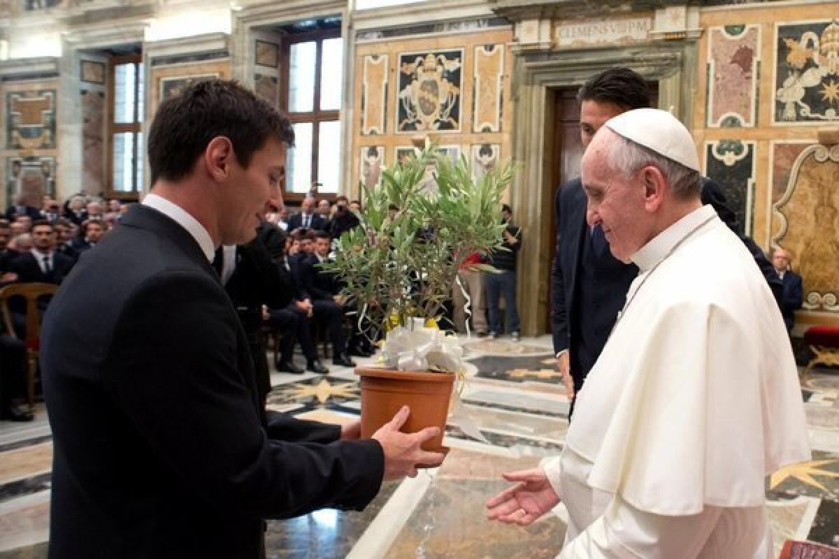 Soccer star Lionel Messi presents and olive tree to Pope Francis.