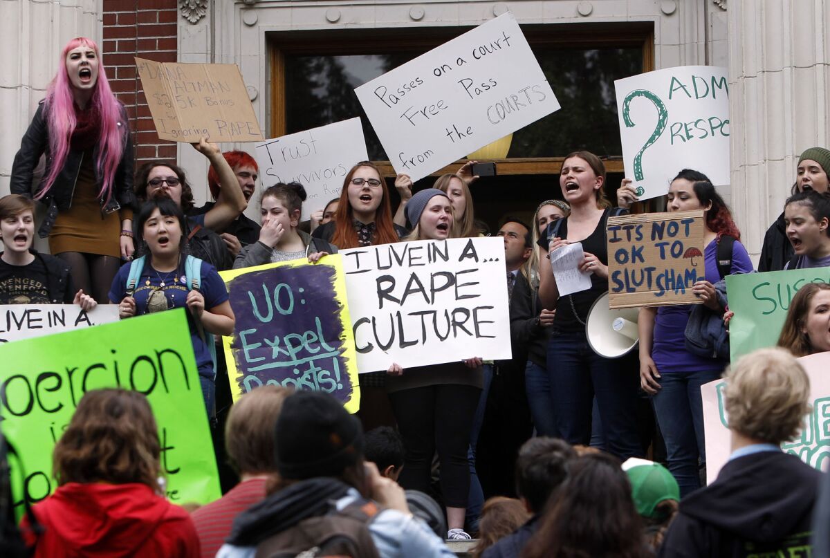 FILE - University of Oregon students and staff protest on the steps of Johnson Hall on the UO campus in Eugene, Ore. Thursday May 8, 2014, against sexual violence in the wake of allegations of rape brought against three UO basketball players by a fellow student. (AP Photo/The Register-Guard, Chris Pietsch, File)