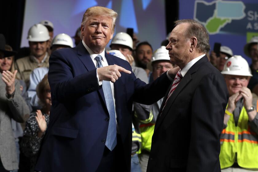 President Donald Trump gestures to Harold Hamm, CEO and majority owner of North Dakota’s largest oil company, Continental Resources, as he arrives to speak at the 9th annual Shale Insight Conference at the David L. Lawrence Convention Center, Wednesday, Oct. 23, 2019, in Pittsburgh. (AP Photo/Evan Vucci)