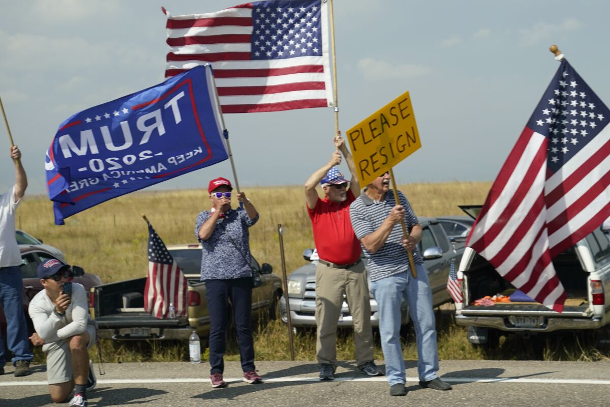 Protesters display signs along a road 