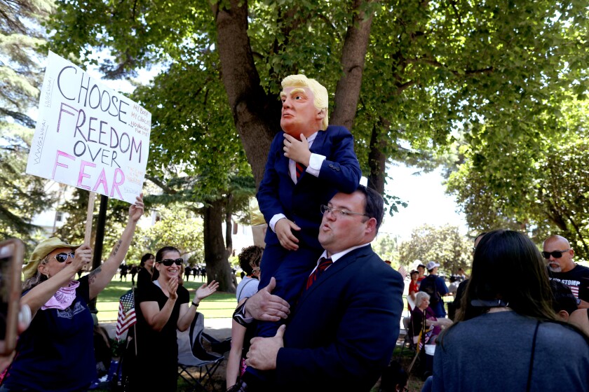 A person playing President Trump at a rally in Sacramento.