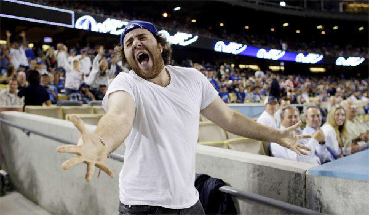 Dodgers fan Jameson Moss serenades the crowd with Journey's raucous "Don't Stop Believin'" during the 8th inning against the San Diego Padres at Dodger Stadium.