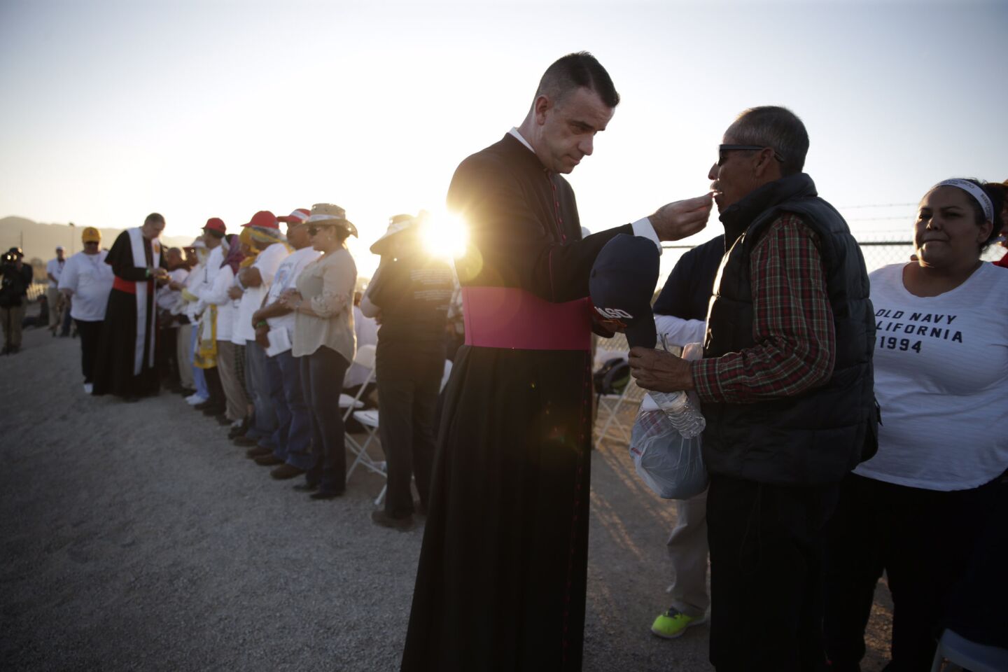 Msgr. James Brownfield gives communion at the levee in El Paso, Texas, near Ciudad Juarez, Mexico, on Wednesday during a Mass celebrated by Pope Francis on the Mexican side of the border.