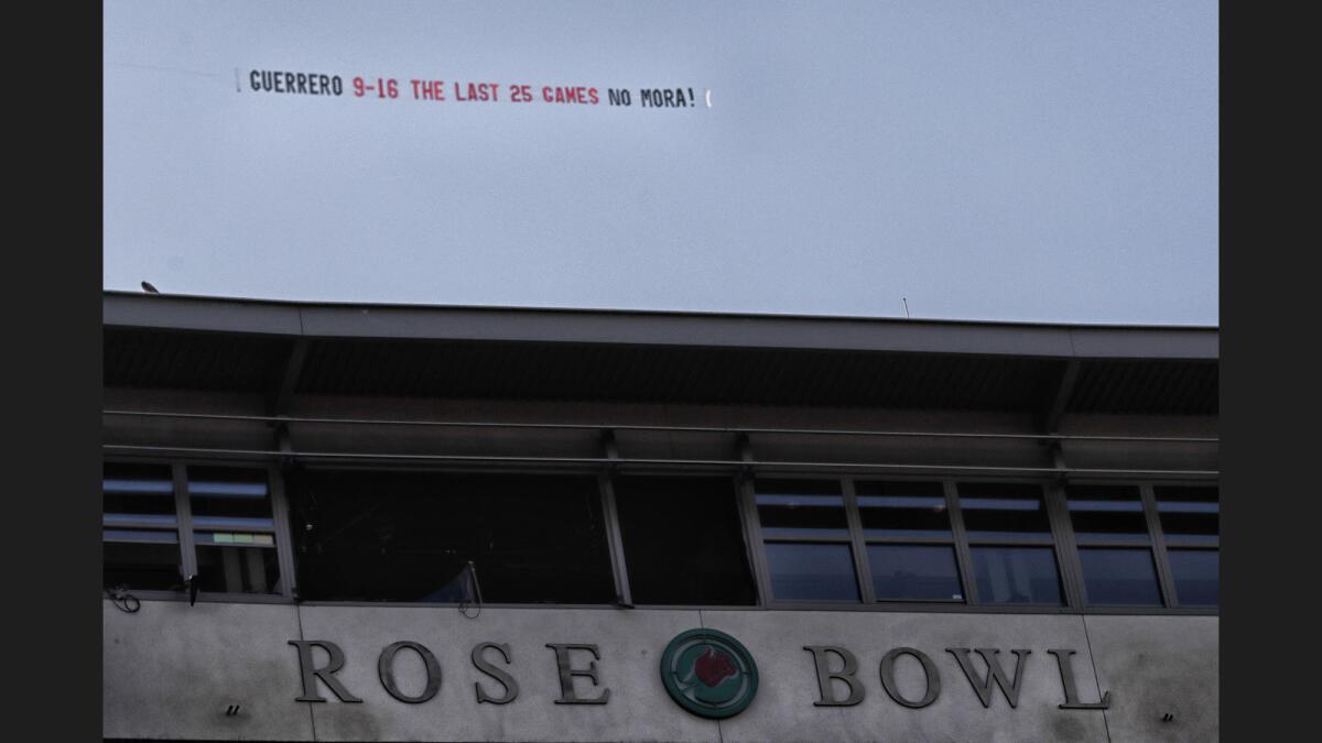 A banner calling for the firing of UCLA head coach Jim Mora flies over the Rose Bowl hours before gametime against Arizona State at the Rose Bowl.