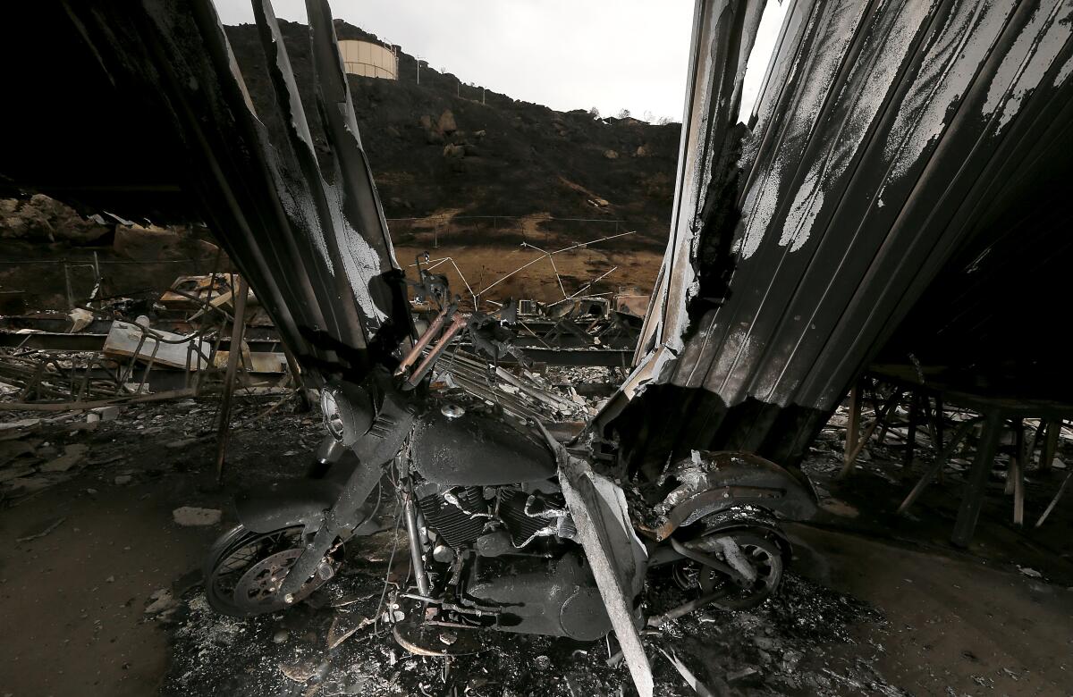 A charred motorcycle stands in a structure destroyed by the Fairview fire near Hemet.