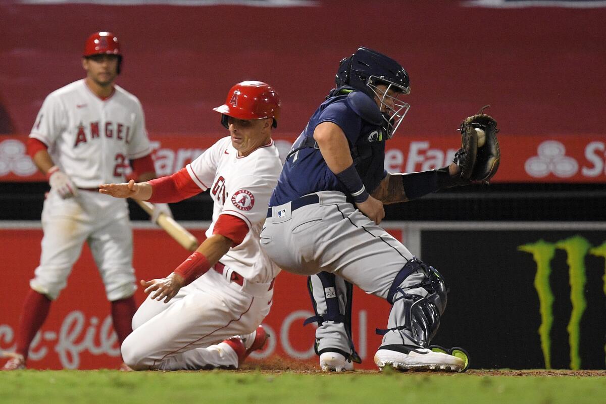 Angels' Jason Castro scores on a double by Brian Goodwin as Seattle Mariners catcher Joseph Odom takes a late throw.