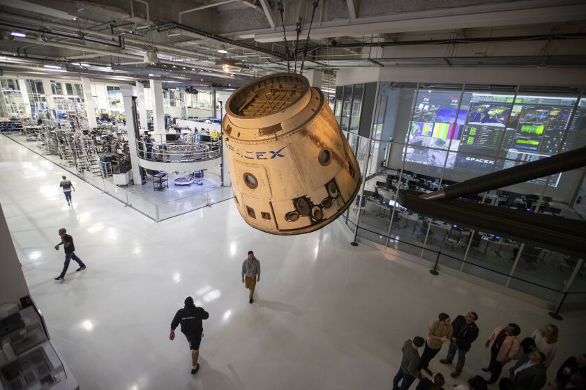 HAWTHORNE, CALIF. -- WEDNESDAY, DECEMBER 19, 2018: The SpaceX Dragon cargo capsule, shown hanging from the ceiling, is the fist one sent to the International Space Station, was launched in 2010 and carried supplies to the space station. NASA Astronauts Robert L. Behnken and Doug Hurley will be flying to the International Space Station and are doing some training at SpaceX HQ in Hawthorne ahead of their first flight next summer. The astronauts practiced docking the Crew Dragon capsule with the space station at SpaceX in Hawthorne, Calif., on Dec. 19, 2018. (Allen J. Schaben / Los Angeles Times)