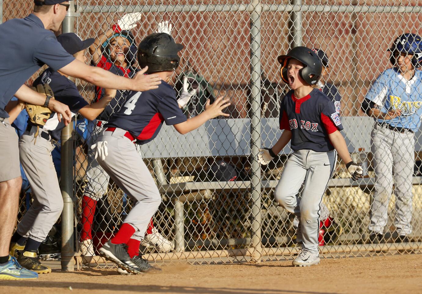 Costa Mesa American Little League's Mason Duncan, right, cheers after scoring the go-ahead run during the sixth inning against Costa Mesa National in the District 62 Tournament of Champions Minor B Division semifinals on Thursday at Ocean View Little League.