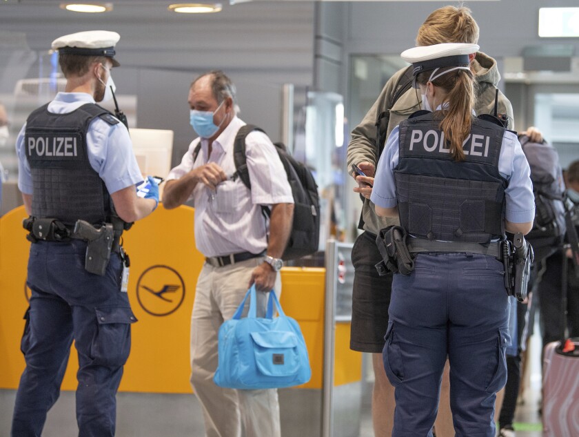 Federal police officers check passengers arriving aboard a flight from Portugal, at Frankfurt airport, Germany, Tuesday June 29, 2021. As of Tuesday, Portugal is being considered a virus variant area, and people arriving in Germany must go into quarantine. (Boris Roessler/dpa via AP)