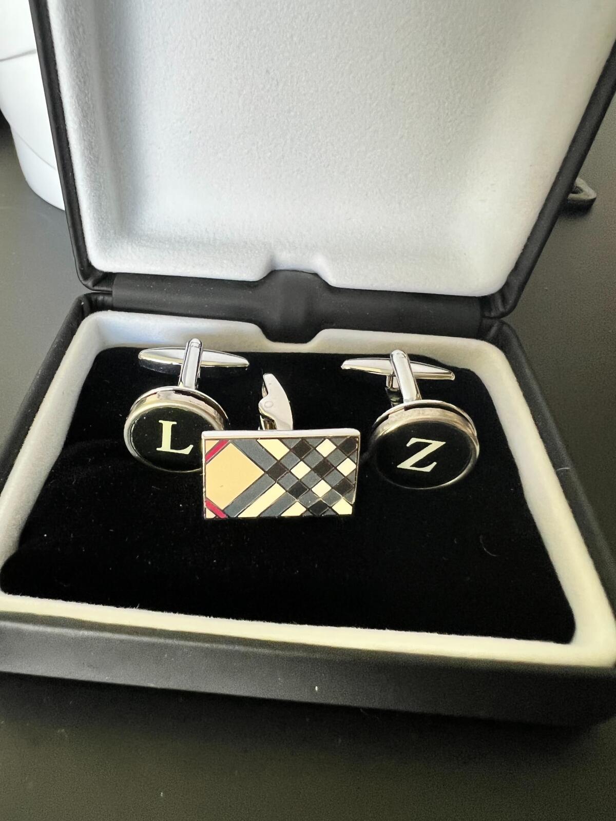 A pair of cuff links in their case, one with the letter L, the other with the letter Z