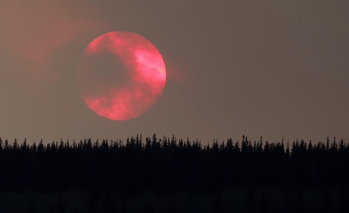 Wildfire smoke masks the sun as it sets over a ridge near South Fork, Colo. The West Fork Complex wildfire in the southwest part of the state grew to nearly 70,000 acres but had destroyed no homes, authorities said.