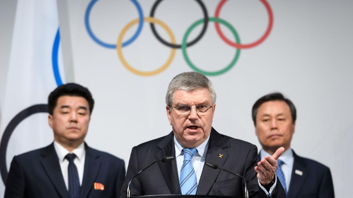 IOC President Thomas Bach is flanked by North Korea's Sports Minister and Olympic Committee President Kim Il Guk, left, and South Korean Minister of Culture, Sports and Tourism Do Jong-hwan.