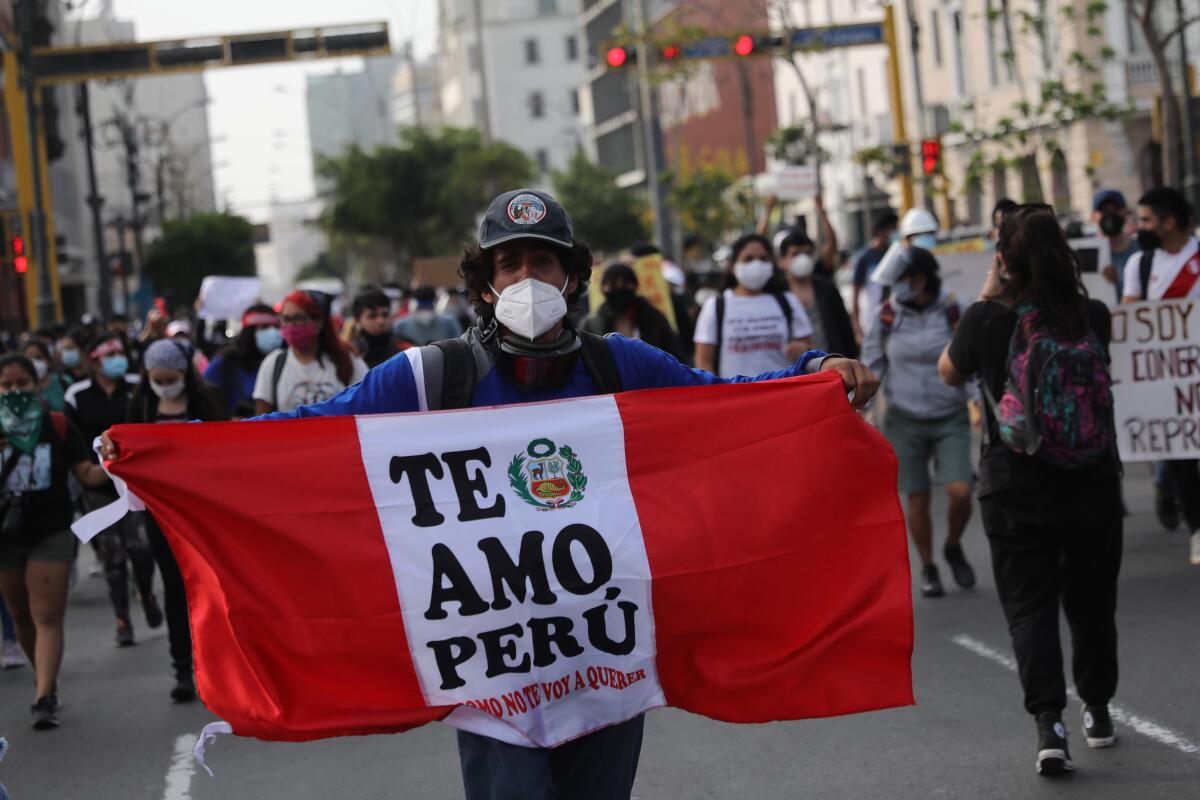 A supporter of ousted Peruvian President Martín Vizcarra holding a banner reading "I love you Peru."