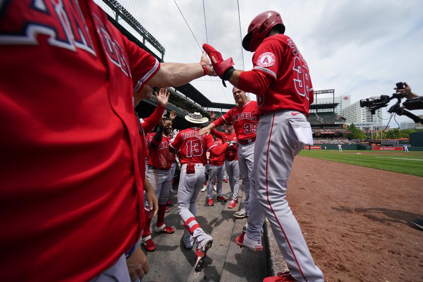 Los Angeles Angels' Monte Harrison (13) wears a cowboy hat as he is greeted in the dugout after hitting a two-run home run to bring in Michael Stefanic (38) during the third inning of a baseball game against the Baltimore Orioles, Sunday, July 10, 2022, in Baltimore. (AP Photo/Julio Cortez)