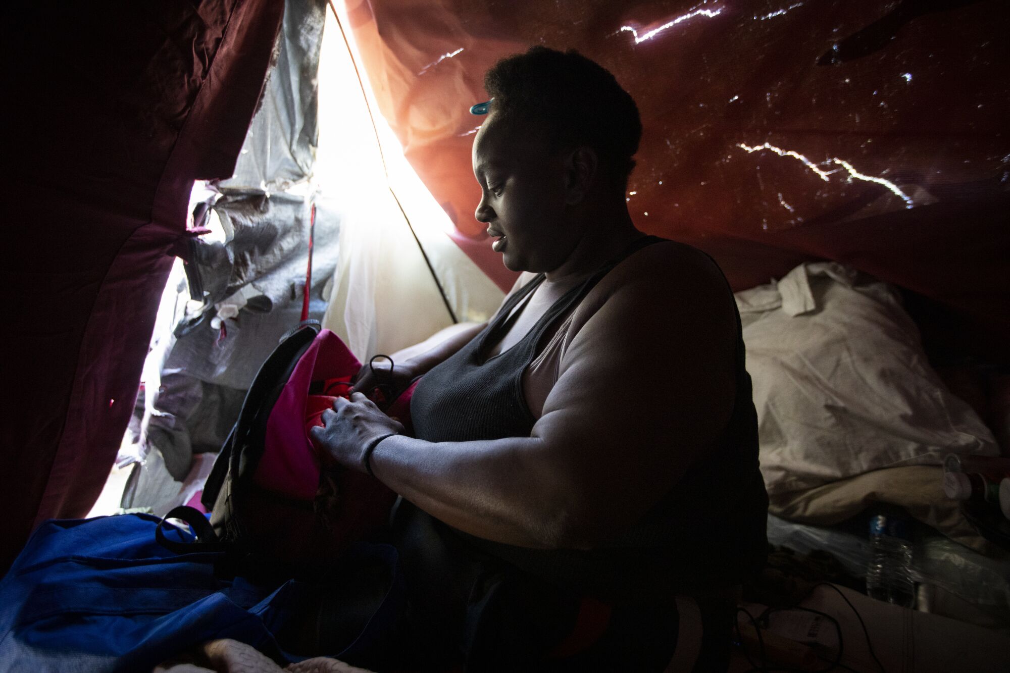 Leneace Pope organizes her belongings inside a tent in Los Angeles.