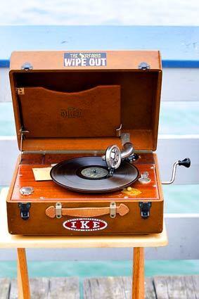 A vintage record player with surfer music stickers on display at the San Clemente pier.