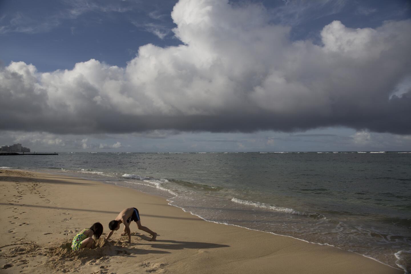Two children visiting from China play on Waikiki Beach in Honolulu. Most of the famed beach fronting Waikiki was closed after heavy rains triggered a half-million gallon sewage spill near Hawaii's world-famous tourist district.