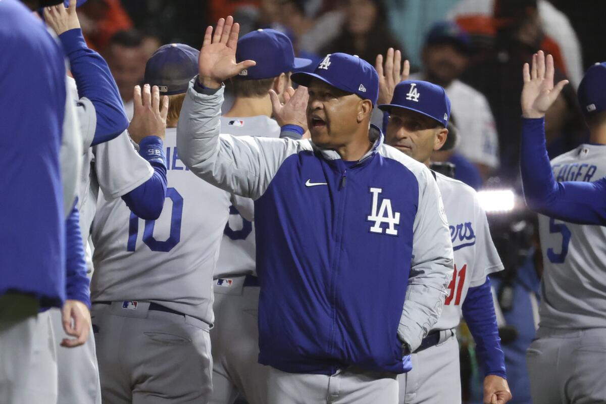 Dodgers manager Dave Roberts celebrates with his players after their NLDS Game 2 win over the Giants on Saturday.