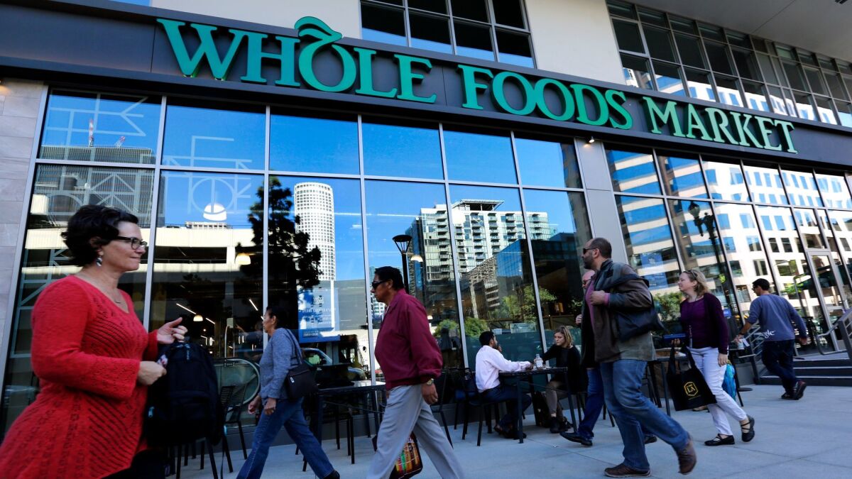 Pedestrians make their way past a Whole Foods Market on Grand Avenue in downtown Los Angeles during the store's grand opening on December 4, 2015. (Mel Melcon / Los Angeles Times)
