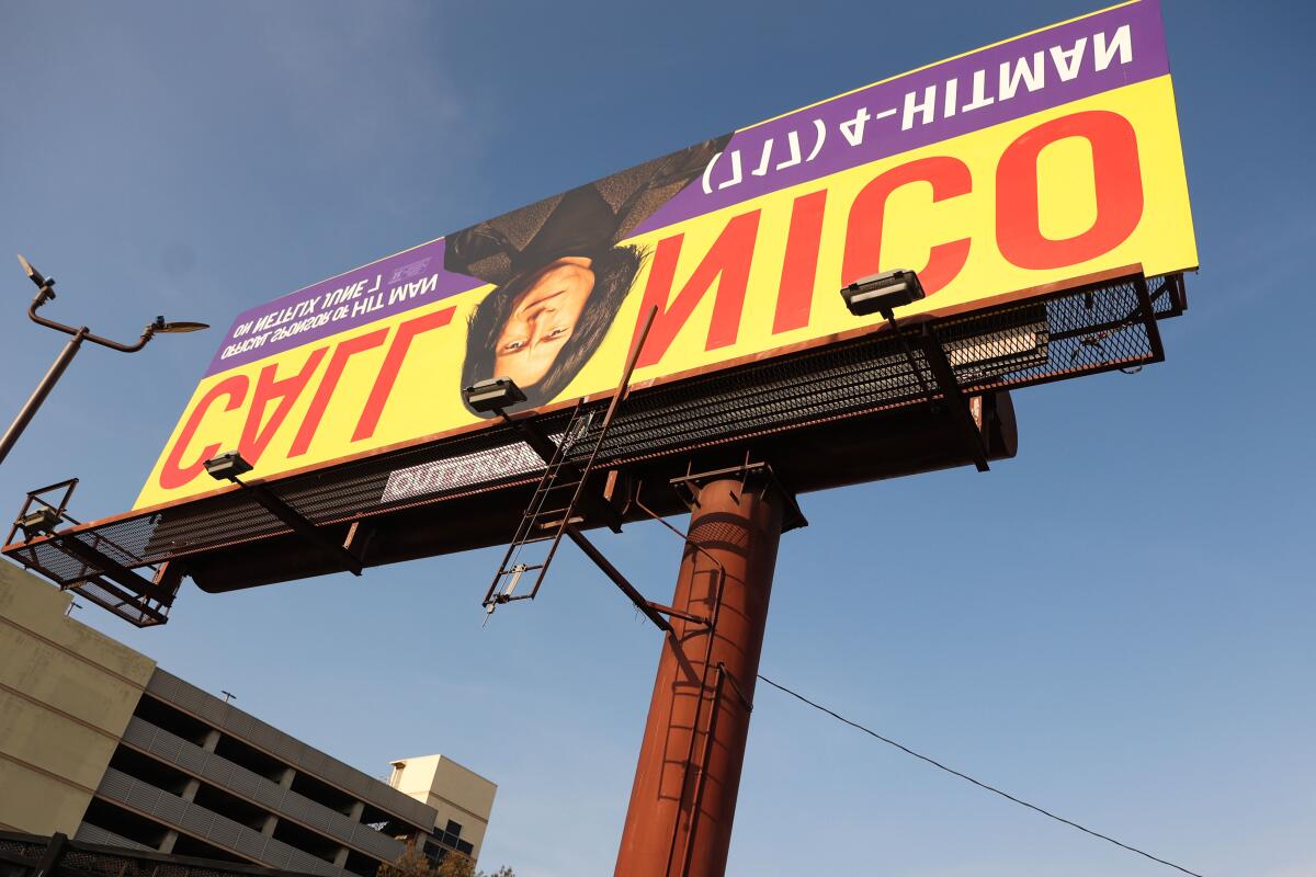 An upside-down billboard that says Call Nico promoting the movie "Hitman"
