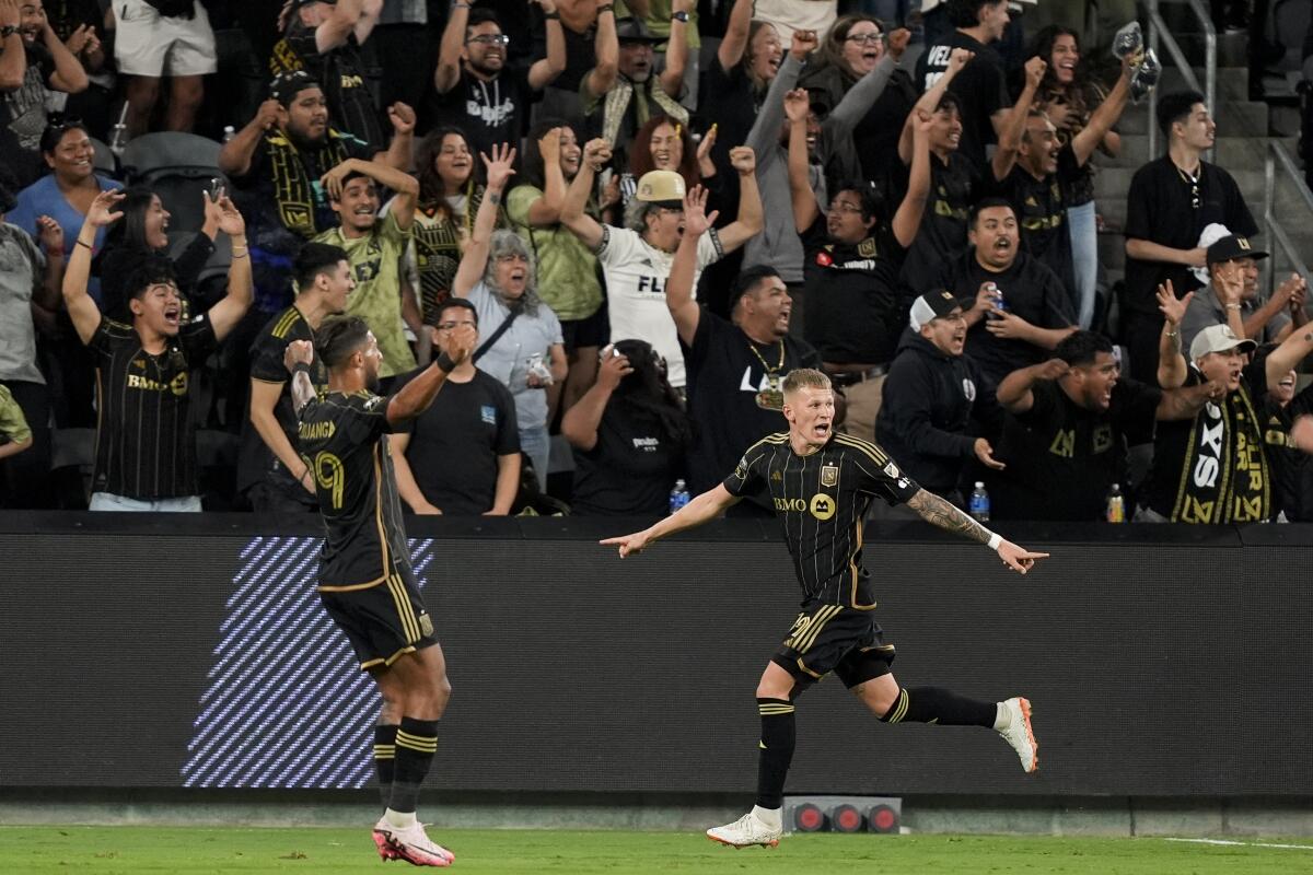 Los Angeles FC midfielder Mateusz Bogusz, right, reacts af 