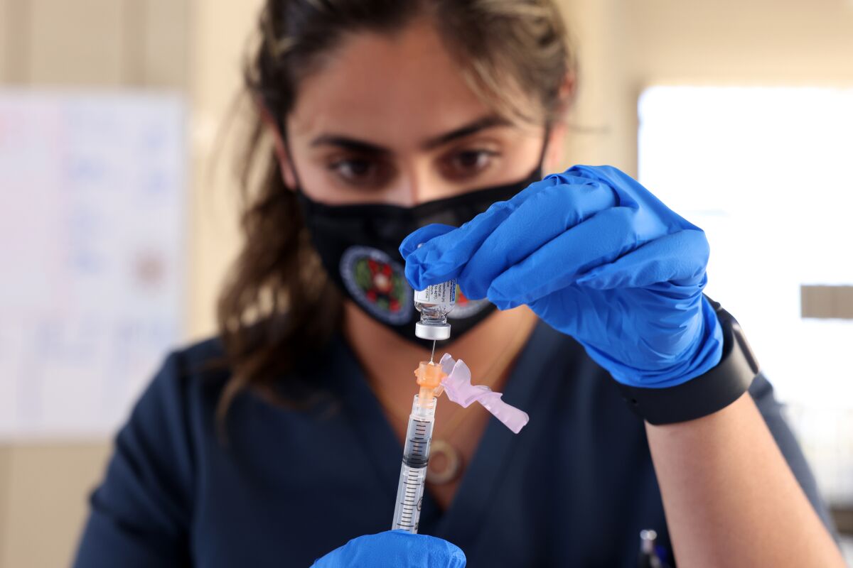 A pharmacist prepares a COVID-19 vaccine 