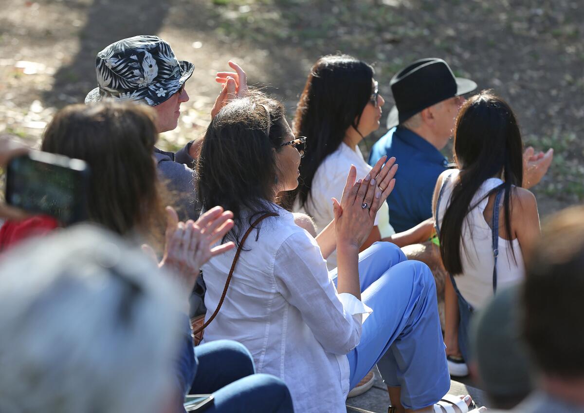Guests applaud a short prayer and poem during the Greater Huntington Beach Interfaith Council prayer vigil.