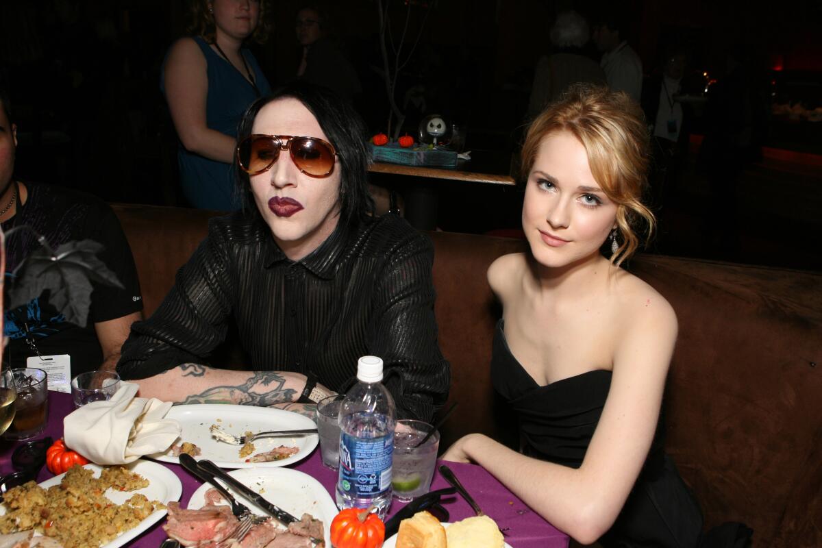 Marilyn Manson and Evan Rachel Wood seated at a round dinner table